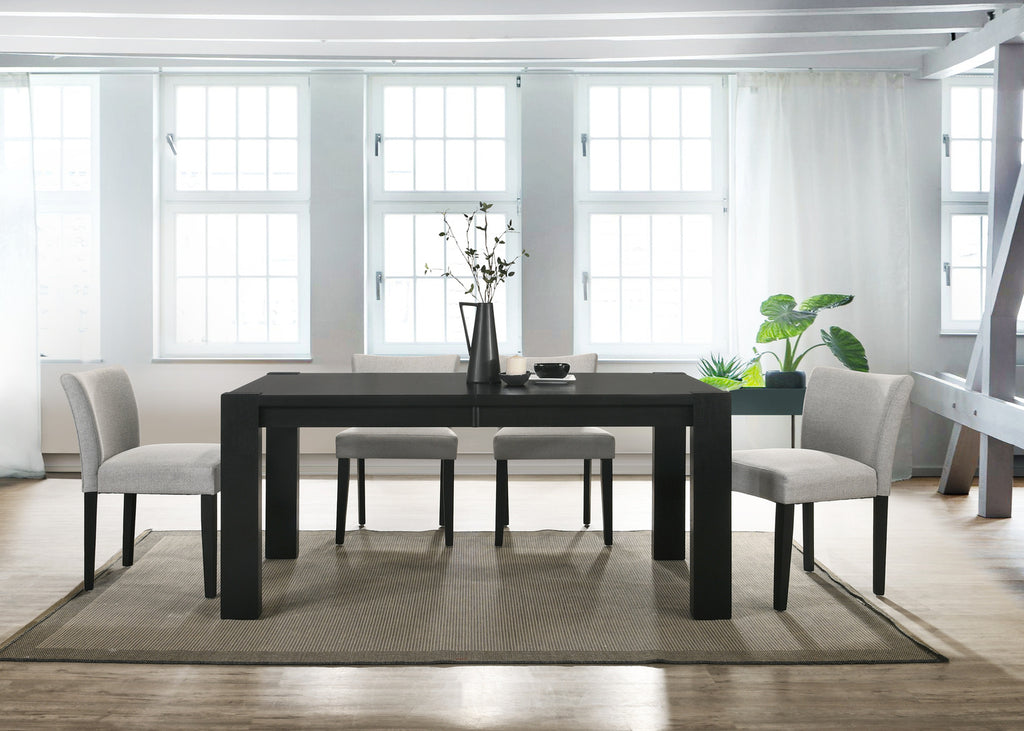 Modern dining room with a black rectangular table and gray chairs in a bright room.