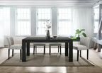 Modern dining room with a black rectangular table and gray chairs in a bright room.