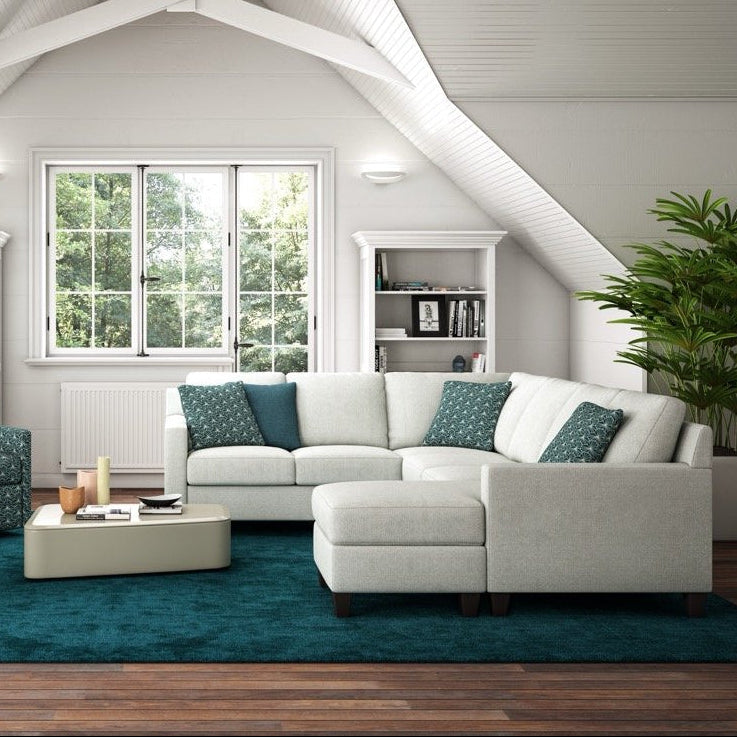 Modern living room with a white sectional sofa, armchair, coffee table, and decorative elements.