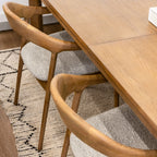 Wooden dining table with chairs on a patterned rug
