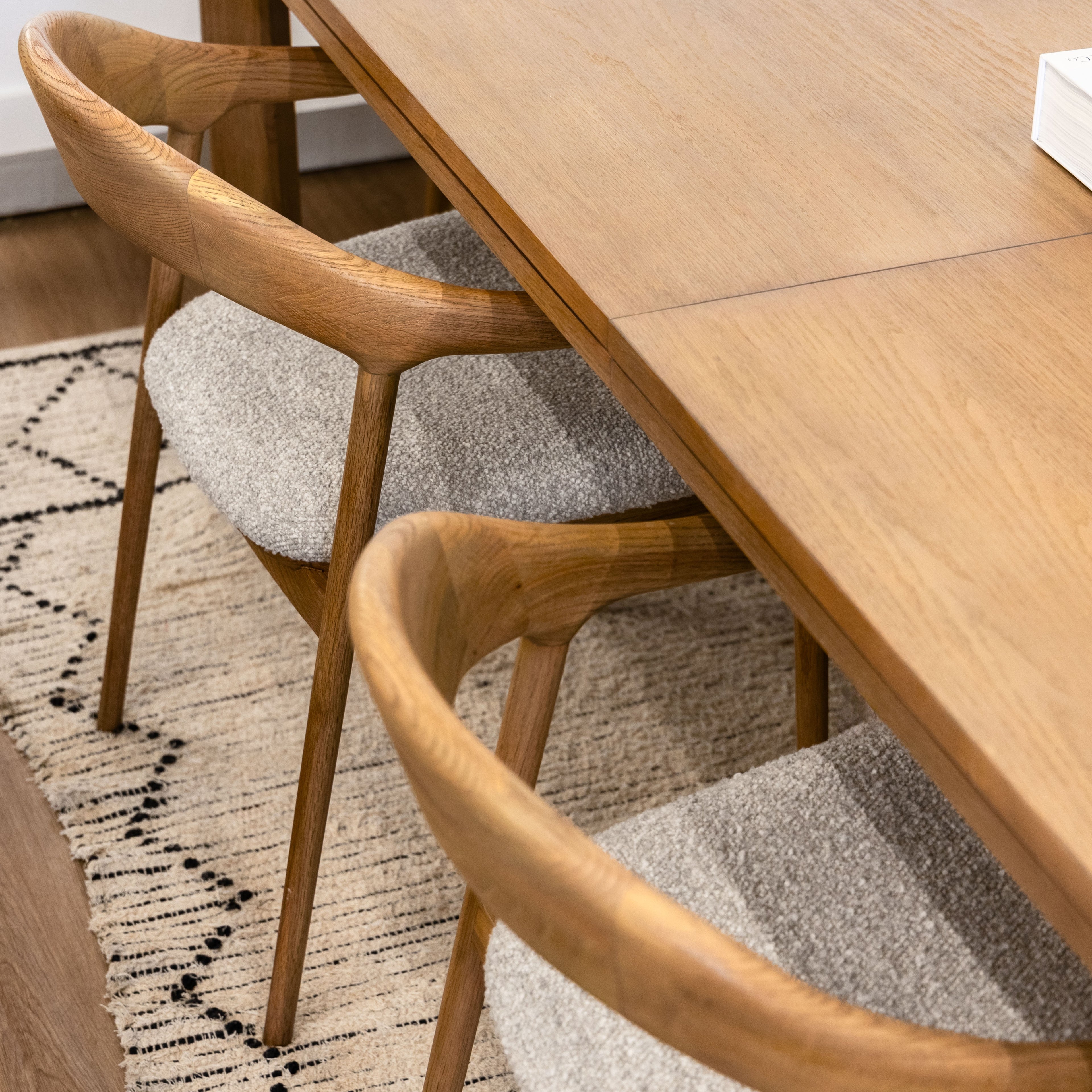 Wooden dining table with chairs on a patterned rug