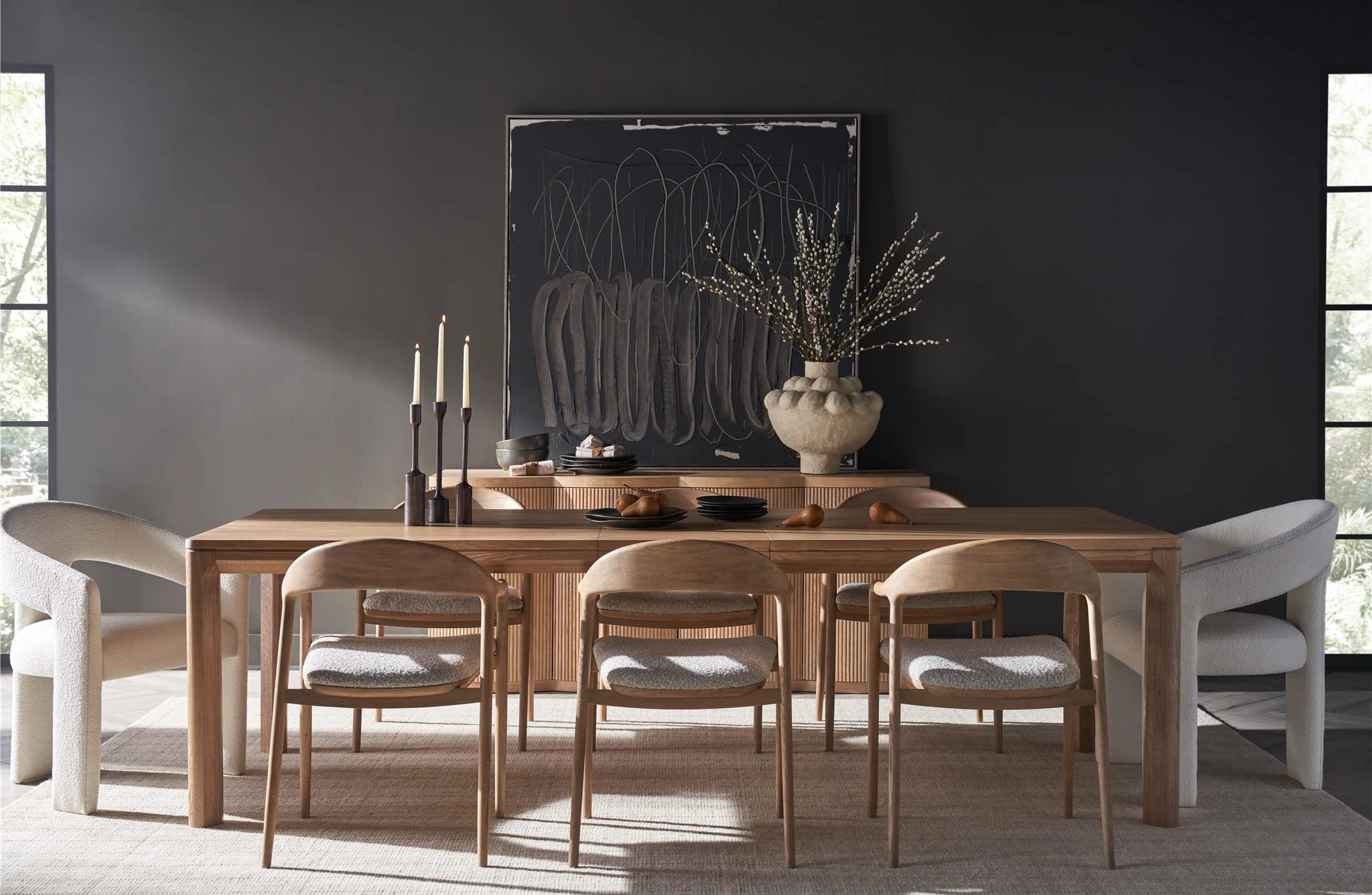 Dining room with wooden table and chairs against a dark wall.