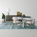 Dining room with a round table, table lamp, and chairs on a blue rug