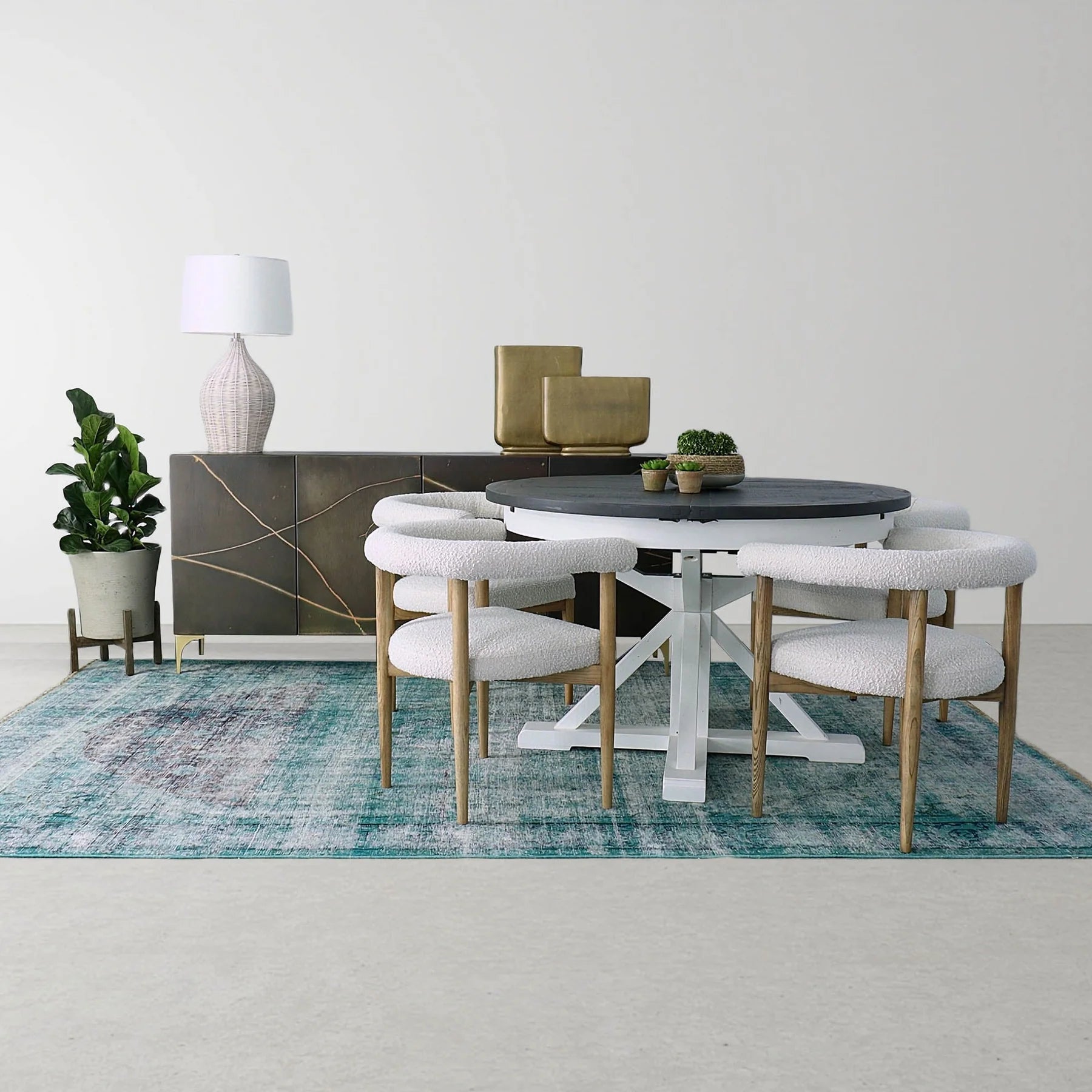 Dining room with a round table, table lamp, and chairs on a blue rug