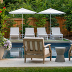 Outdoor seating area with chairs, tables, and umbrellas by a pool