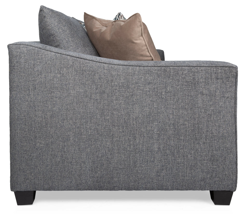 Gray upholstered chair with two pillows on a white background