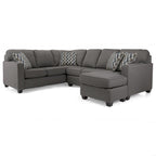 Gray sectional sofa with patterned cushions on a white background