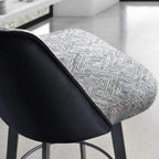 Bar stool with black seat and gray patterned backrest in a modern kitchen setting.