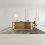 Wooden sideboard with a lamp and plant in a minimalistic room.