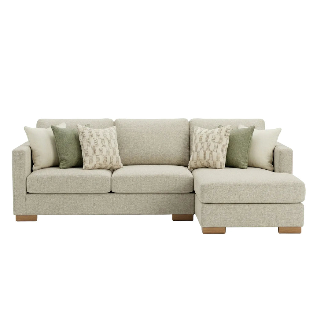 Beige sectional sofa with patterned cushions on a white background